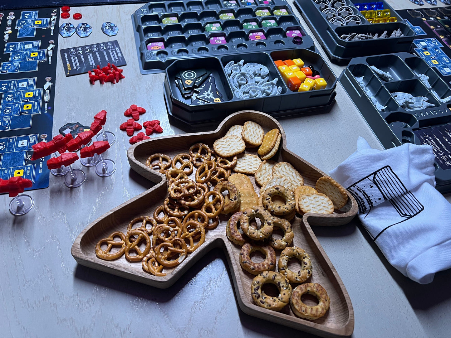 Big Meeple shaped tray filled with crackers on a table with Eclipse board game elements in the background